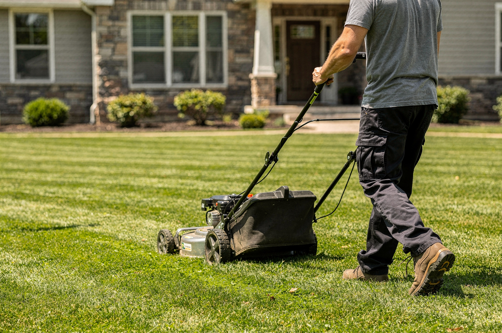 lawn care professional mowing neat grass in residential yard v2 Top Delta BC Home Service Landscapers lawn care professional mowing neat grass in residential yard